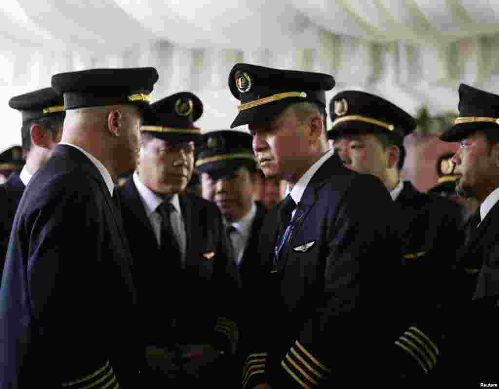 Pilots attend the wake of MH17 co-pilot Eugene Choo, after the return of his remains in Seremban, Sept. 2, 2014.