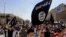 Demonstrators chant pro-al-Qaida-inspired Islamic State of Iraq and the Levant (ISIL) as they carry al-Qaida flags in front of the provincial government headquarters in Mosul, 225 miles (360 kilometers) northwest of Baghdad, Iraq, June 16, 2014.