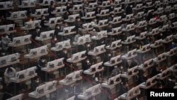 មនុស្សម្នា​ពាក់​ម៉ាស់​ធ្វើ​ការ​នៅ​មជ្ឈមណ្ឌល​ដេញ​ថ្លៃ​ផ្កា បន្ទាប់​ពី​មាន​ការ​ផ្ទុះ​ឡើង​នូវ​មេរោគ​កូរ៉ូណា​វីរុស នៅ​ក្នុង​ប្រទេស​ចិន ក្នុង​ក្រុង Kunming ខេត្ត Yunnan ប្រទេស​ចិន កាលពី​ថ្ងៃទី១០ ខែកុម្ភៈ ឆ្នាំ២០២០។