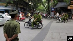 Policemen on motorcycle in Hanoi, Vietnam, June 11, 2010