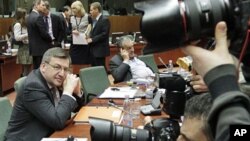 Belgium's FM Steven Vanackere (L) watches the media during an EU foreign ministers meeting at the European Council building in Brussels, Feb 21 2011