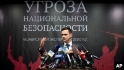 Russian opposition activist Ilya Yashin speaks while presenting a report on Chechen leader Ramzan Kadyrov, in Moscow, Feb. 23, 2016. The banner behind him reads: "National Security Threat." 