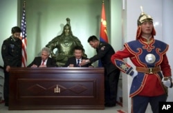 美国国防部长哈格尔与蒙古国防部长巴特额尔德尼在蒙古国防部参加签署联合声明的仪式。（2014年4月10日）