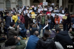 Romanian immigrant Nicolae Hent, a taxi driver and friend of Nicanor Ochisor, addresses a crowd of taxi drivers and media from the steps of New York's City Hall. (R. Taylor/VOA)
