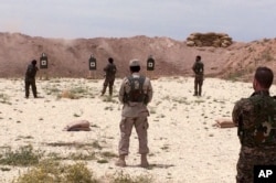 Syrian Arab trainees practice firing their small arms at an undisclosed training range in northern Syria on May 21, 2016.