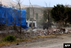 FILE - Wreckage lies on the ground in front of a Turkish military station covered by a tarpaulin after a suicide attack on August 2, 2015 in east Turkey town Dogubeyazit in Agri Province.