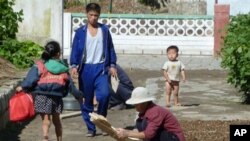 This photo taken on September 23, 2010 shows residents drying crops outside their homes at a collective farm located about 20 kilometers from the center of Pyongyang