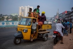 Migrant laborers wearing masks as a precaution against the coronavirus leave for work in Kochi, Kerala state, India, Feb. 18, 2021.