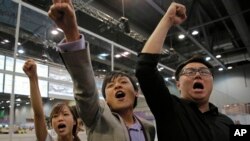 Radical activist candidates from Youngspiration group, from left, Yau Wai-ching, Kenny Wong and Henry Wong shout slogans as they celebrate after Yau won the legislative council election in Hong Kong, Monday, Sept. 5, 2016.