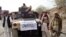 Armed militants of Tehreek-e-Taliban Pakistan (TTP) pose for photographs next to a captured armored vehicle in the Pakistan-Afghanistan border town of Landikotal on November 10, 2008, after they hijacked supply trucks bound for Afghanistan.