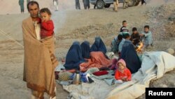 An Afghan family waits for help from the government and aid organizations in Takhar, Afghanistan, Oct. 11, 2016, after fleeing their homes in neighboring Kunduz, which has been the scene of fighting between militants and government troops.