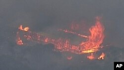 This image made from video shows a house on fire from a bushfire, Dec. 23, 2019, in Gumeracha, South Australia.