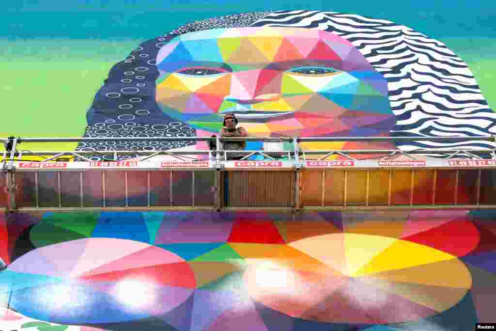 Pelukis Spanyol, Okuda berpose dengan lukisan mural setinggi 50-meter karyanya yang menggambarkan sosok &quot;Mona Lisa&quot; di Paris, Perancis.