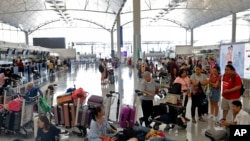 Travelers wait to check in for their flights at the airport in Hong Kong, Aug. 14, 2019. Flights resumed at Hong Kong's airport Wednesday morning. 