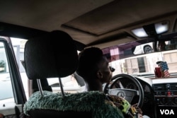 Taxi driver Eduardo poses for a portrait in his taxi. He asked to have his identity hidden, but said the government impasse has dealt a blow to his income, Dec. 14, 2017. (R. Shyrock)