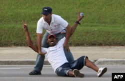 A Cuban dissident is prevented by security personnel from approaching the popemobile as Pope Francis arrives at Revolution Square in Havana, Sept. 20, 2015.