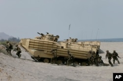 FILE - U.S. and Philippine troops disembark from an assault vehicle during a joint exercise at the Naval Education and Training Command at San Antonio township, Zambales province, northwest of Manila, Philippines.