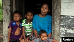 Claudia Maquin, mother of Jakelin Caal Maquin, a 7-year-old girl who died in U.S. custody, stands with her other children outside her house in Raxruha, Guatemala, Dec. 15, 2018.