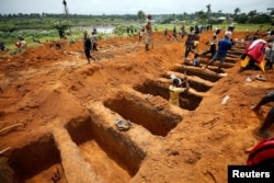 Workers dig graves for mudslide victims at the Paloko cemetery in Waterloo, Sierra Leone, Aug. 17, 2017.
