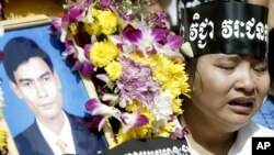 រូបឯកសារ៖ សមាជិក​សហជីព​មួយ​រូប​យំ​នៅ​ក្បែរ​កម្រង​ផ្កា​​ដែល​មាន​រូបថត​លោក ជា វិជ្ជា ប្រធាន​សហជីព​សេរី​កម្មករ ក្នុង​អំឡុង​ពេល​ពិធី​បុណ្យ​សព​របស់​លោក​កាល​ពី​ថ្ងៃ​អាទិត្យ​ទី​២៥ ខែ​មករា ឆ្នាំ​២០០៤ នៅ​រាជធានី​ភ្នំពេញ។ (AP Photo/Andy Eames)