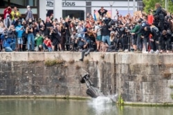 FILE - The statue of 17th century slave trader Edward Colston falls into the water after protesters pulled it down during a protest against racial inequality, in Bristol, Britain, June 7, 2020. (Keir Gravil via Reuters)