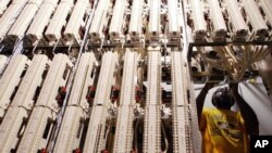  Verizon special service technician Mark Rose adjusts cables attached to a framework in a Verizon network room at the Main Post Office in New York. (File photo)