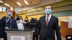 Albin Kurti, right, a candidate for prime minister of Vetevendosje (Self-Determination), casts his ballot paper in parliamentary elections in capital Pristina, Kosovo, Feb. 14, 2021.