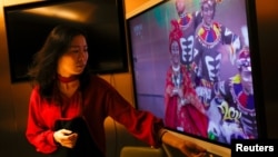 一名女子在北京一家海底撈餐廳和家人吃年夜飯時觀看央視春節晚會（2021年2月11日）