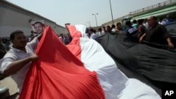 Supporters of Egypt's deposed president Hosni Mubarak wave a large national flag in front of Torah Prison in Cairo, Aug. 22, 2013. 