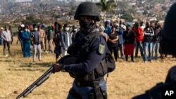 An armed policeman patrols as Police Minster Bheki Cele visits Phoenix, a neighborhood severely affected by unrest and racial tensions near Durban, South Africa, July 17, 2021.