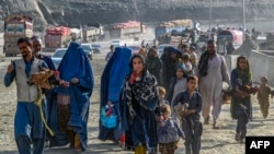 Para pengungsi Afghanistan menyeberangi perbatasan Pakistan-Afghanistan di Torkham, 27 Oktober 2023. (Foto: Abdul Majeed/AFP)