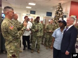 FILE - In this Dec. 22, 2017, file photo, Lt. Gen. Stephen Townsend takes a photo of Defense Secretary Jim Mattis and a dining facility worker at Fort Bragg, North Carolina.
