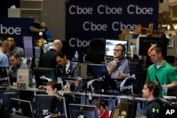Traders work in a trading pit at the Chicago Board Options Exchange, Monday, Dec. 11, 2017, in Chicago