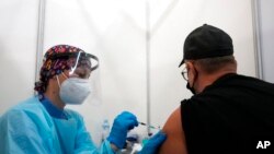 Seorang petugas kesehatan menyuntikan vaksin COVID-19 dari Pfizer kepada Vitaly Pavlov dari Rostov-on-Don di sebuah pusat vaksinasi di Belgrade, Serbia, 2 Oktober 2021.