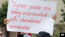  A woman holds a placard during a protest in solidarity with residents of the Syrian capital's eastern suburb of Ghouta, in front the Russian embassy in Beirut, Lebanon, Sunday, Feb. 25, 2018.