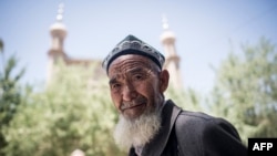 Seorang pria Muslim setempat setelah salat Jumat di depan sebuah Masjid di Hotan, di Daerah Otonomi Uighur Xinjiang, China, 23 Juni 2017. (Foto: AFP)