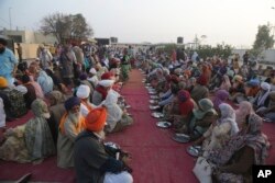 Sikh pilgrim wait for food at the shrine of their spiritual leader Guru Nanak Dev in Kartarpur, Pakistan, Nov. 28, 2018.
