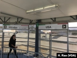 A woman walks toward the sign pointing to the United States in this undated photo.
