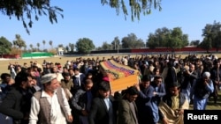 FILE - Afghan men carry the coffin of journalist Malalai Maiwand, who was shot and killed by unknown gunmen in Jalalabad, Afghanistan, Dec. 10, 2020.