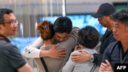 អ្នកធ្វើដំណើរតាមជើងហោះហើរ SQ321 របស់ក្រុមហ៊ុនអាកាសចរណ៍ Singapore Airlines ដែលចុះចតអាសន្ននៅប្រទេសថៃ បានជួបជុំគ្រួសារ​នៅ​អាកាសយានដ្ឋាន​អន្តរជាតិ Changi ក្នុងប្រទេសសិង្ហបុរី នាថ្ងៃទី២២ ខែឧសភា ឆ្នាំ២០២៤។ 