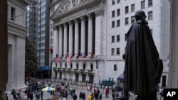 People stand near a statue of George Washington, adjacent to the New York Stock Exchange, Dec. 22, 2018, at the closed Federal Hall National Memorial in New York. A partial shutdown of the government has added another threat to a growing list of economic risks.