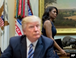 FILE - In this March 12, 2017 file photo, White House Director of communications for the Office of Public Liaison Omarosa Manigault, right, walks past President Donald Trump during a meeting on healthcare in the White House.