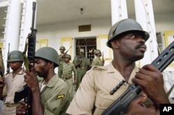 FILE - Haitian soldiers stand guard outside the military headquarters in Port-au-Prince, Haiti, Sept. 18, 1994.