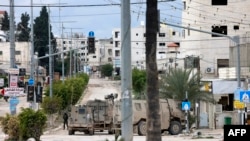 Israeli troops man a position at the entrance of the occupied West Bank refugee camp of Tulkarem, during an ongoing military raid on Feb. 21, 2025. 