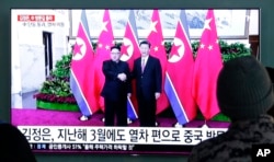 People watch a TV screen showing file footage of North Korean leader Kim Jong Un and Chinese President Xi Jinping, right, during a news program at the Seoul Railway Station in Seoul, South Korea, Jan. 8, 2019. The Korean letters on the screen read: "Kim Jong Un visited China last March."