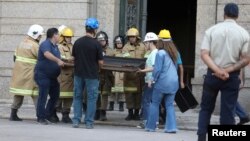 Rescue workers and museum staff carry a picture at the National Museum of Brazil in Rio de Janeiro, Brazil, Sept. 3, 2018. 