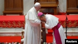 Thai Bishop Joseph Prathan Sridarunsil kisses the hand of Pope Francis during the latter's visit to St. Peter’s Parish church in the Sam Phran district of Nakhon Pathom Province, Thailand, Nov. 22, 2019.