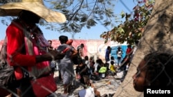 Personas que huyen de la violencia llegan a una comisaría de la Policía Nacional de Haití, tras un tiroteo entre bandas rivales, en Puerto Príncipe, Haití, el 12 de febrero de 2024.