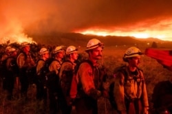 Firefighters from Cal Fire's Placerville station monitor the Sugar Fire, part of the Beckwourth Complex Fire, in Doyle, Calif., July 9, 2021.