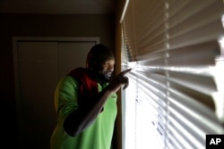Joe Evans, a Jefferson County Republican, shows on Sept. 26, 2017 how a month earlier he watched from the window as Hurricane Harvey's downpour stretched into its second day in Beaumont, Texas.